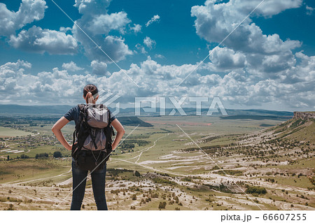 Hiker with backpack relaxing on top of a mountain Hiker with backpack relaxing on top of a mountain 66607255