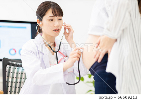 医者が妊婦の胎児の心音を聞いている 66609213