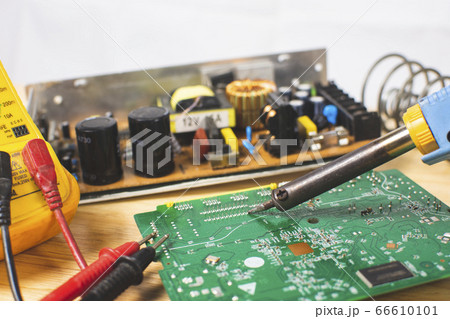 Technician is using electric soldering iron Technician is using electric soldering iron 66610101