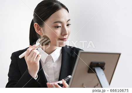 メイクをするスーツ姿の若い女性 就活 社会人メイク イメージの写真素材