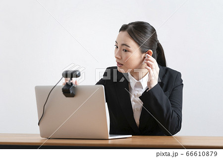 オンラインミーティングのの準備をするスーツ姿の若い女性 66610879