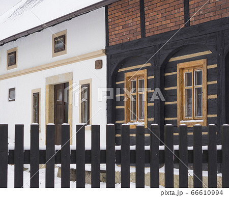 view from wooden plank fence on timbered cottage open front door in winter and snow view from wooden plank fence on timbered cottage open front door in winter and snow 66610994