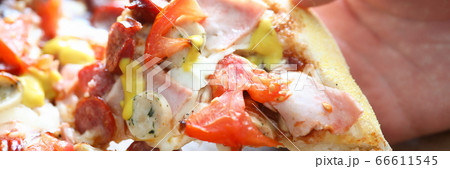 Male hand holding big piece of tasty fresh pizza 66611545