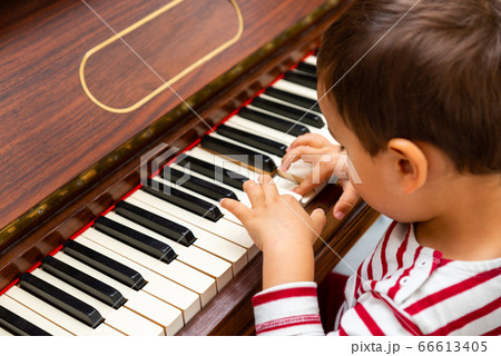 Litlle boy playing the piano 66613405