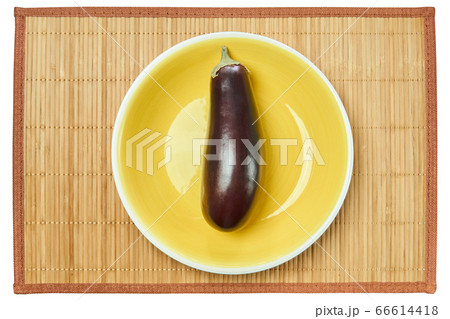 violet eggplant on a yellow plate on a cane place violet eggplant on a yellow plate on a cane place 66614418