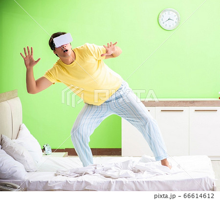 Young man with virtual glasses in the bedroom Young man with virtual glasses in the bedroom 66614612