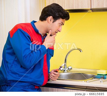 Plumber repairing tap at kitchen Plumber repairing tap at kitchen 66615695