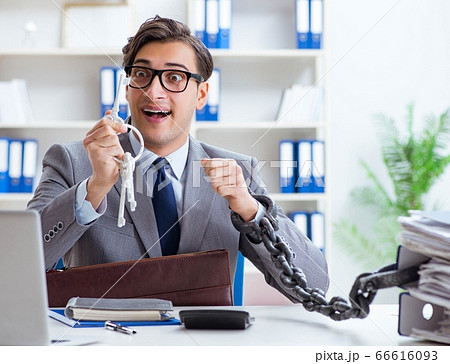 Busy employee chained to his office desk 66616093