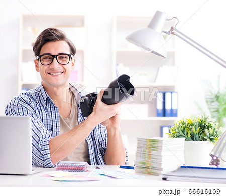 Young photographer working with his camera Young photographer working with his camera 66616109