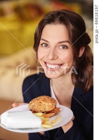 Pretty joyful woman with plate of fast food. Pretty joyful woman with plate of fast food. 66616197