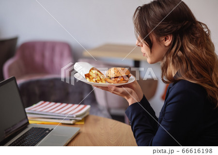 Woman in profile with plate of food in her hands Woman in profile with plate of food in her hands 66616198