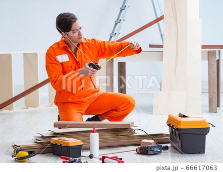 Contractor working on laminate wooden floor Contractor working on laminate wooden floor 66617063