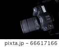 Top view professional digital camera with a zoom lens and a leather strap on a black background with copy space. View from above. Realistic 3d render. Place for advertising text. Reflection at bottom 66617166