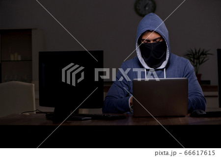 Male hacker hacking security firewall late in office Male hacker hacking security firewall late in office 66617615