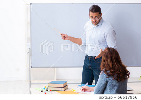 Young female student and male teacher in the classroom Young female student and male teacher in the classroom 66617956