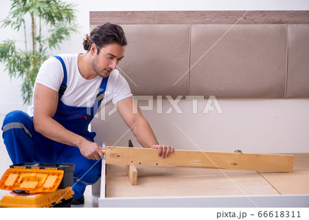 Young male contractor installing furniture at home Young male contractor installing furniture at home 66618311