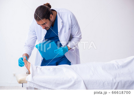 Police coroner examining dead body corpse in morgue Police coroner examining dead body corpse in morgue 66618700