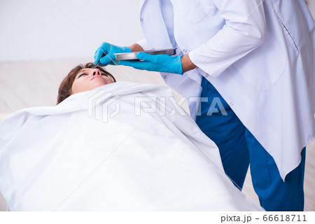 Police coroner examining dead body corpse in morgue 66618711