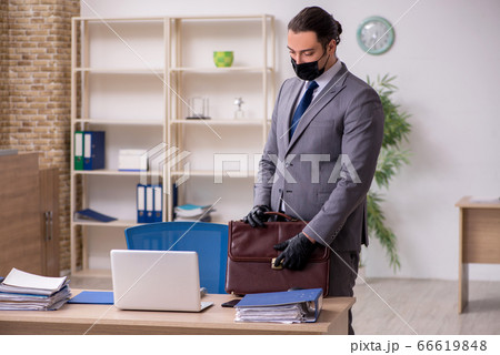 Young male employee in the office during pandemic disease 66619848