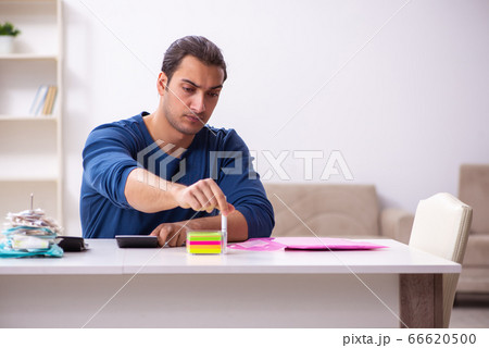 Young man in budget planning concept Young man in budget planning concept 66620500