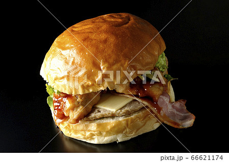 ベーコンとチーズとレタスとチキンがサンドされた大きいハンバーガー（黒背景） 66621174