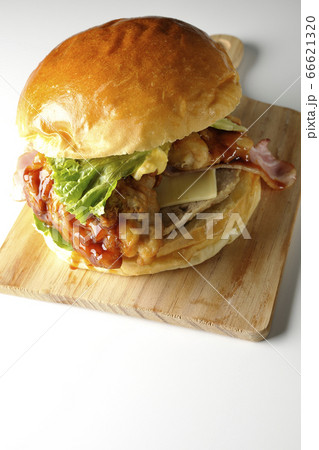 たっぷりのタレがしたたるベーコンとチーズとレタスとチキンがサンドされた大きいハンバーガー(白背景) たっぷりのタレがしたたるベーコンとチーズとレタスとチキンがサンドされた大きいハンバーガー(白背景) 66621320