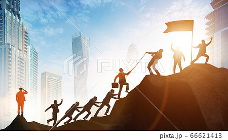 Concept of teamwork with team climbing mountain top 66621413