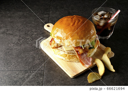 ベーコンとレタスとチーズとチキンがサンドされた大きいハンバーガーコーヒーポテトセット 66621694