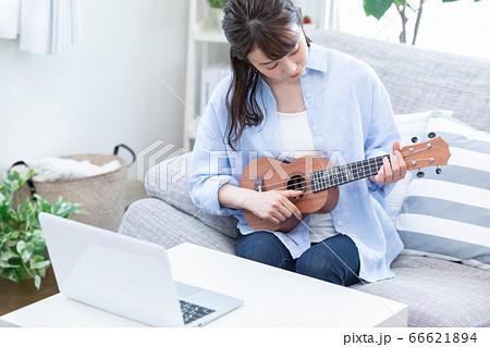 オンラインで楽器（ウクレレ）のレッスンを受ける若い女性 66621894