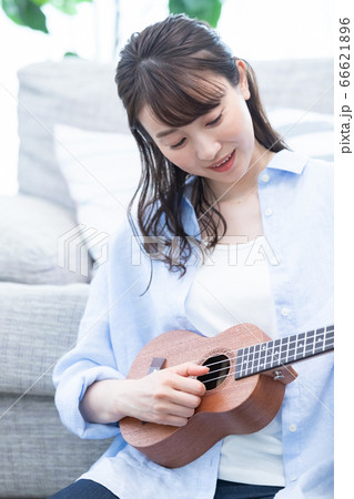自宅でウクレレを弾く女性の写真素材 [66621896] - PIXTA