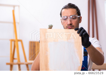 Young male contractor working in workshop Young male contractor working in workshop 66623529