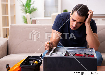 Young man repairing computer at home Young man repairing computer at home 66624796