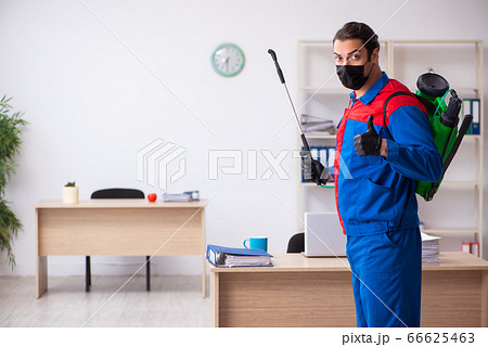 Young male contractor disinfecting office 66625463