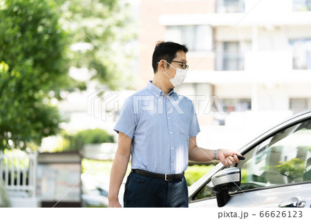 車に鍵をかけるミドル男性 66626123