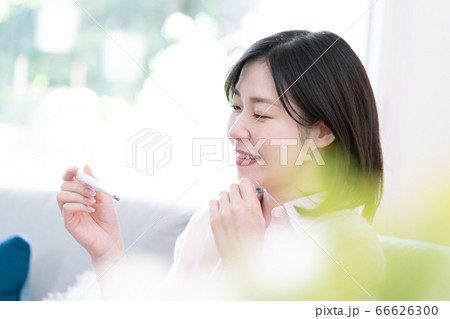 体温を計ってホッとしているミドル女性【リビング】 体温を計ってホッとしているミドル女性【リビング】 66626300