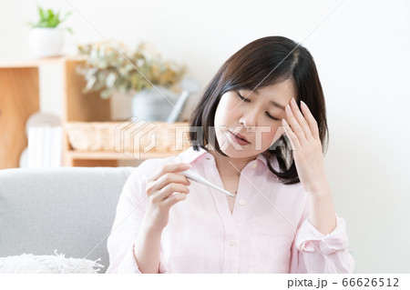 体調不良なミドル女性【体温計】 66626512