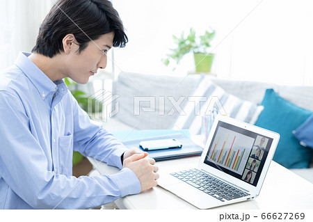 自宅でテレビ会議に参加する若い男性 66627269