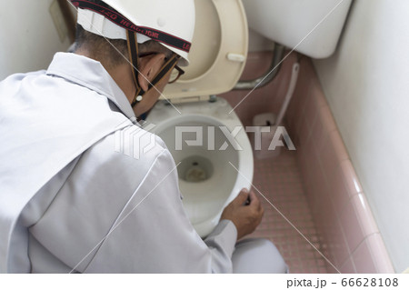 旧式の水洗トイレを調査するビジネスマン 住宅 リフォーム 解体前 旧式の水洗トイレを調査するビジネスマン 住宅 リフォーム 解体前 66628108