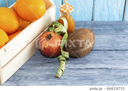 A lot of oranges in the box and a bottle of juice, red pomegranate, coconut. Healthy diet. A lot of oranges in the box and a bottle of juice, red pomegranate, coconut. Healthy diet. 66629755