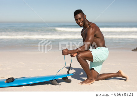 African American man and surf board on the beach African American man and surf board on the beach 66630221