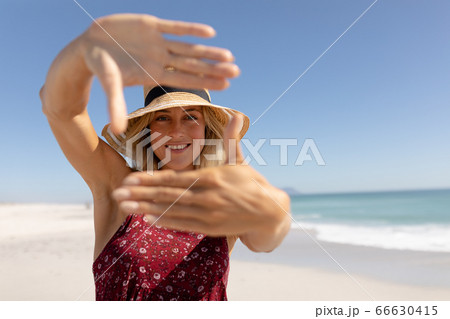 Caucasian woman standing on the beach 66630415