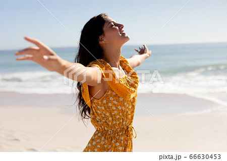 Caucasian woman standing on the beach 66630453