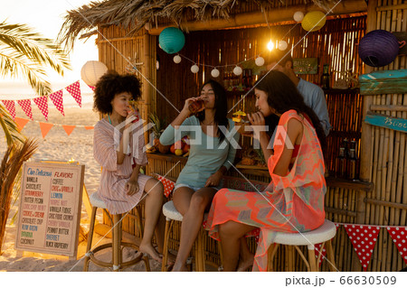 Mixed race friends having fun on beach 66630509