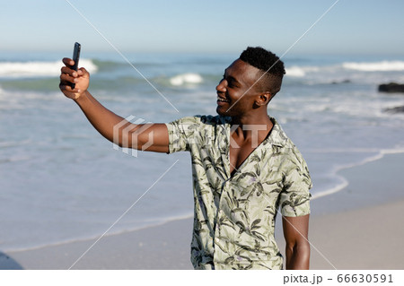 African american man taking a selfie on the beach African american man taking a selfie on the beach 66630591