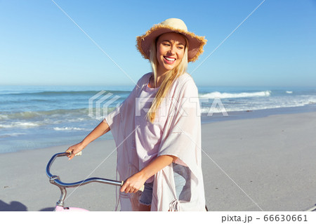Caucasian woman spending time seaside and riding a bike Caucasian woman spending time seaside and riding a bike 66630661
