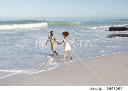 Happy couple spending time together on the beach Happy couple spending time together on the beach 66630664