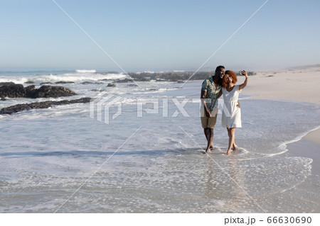 Happy couple spending time together on the beach Happy couple spending time together on the beach 66630690