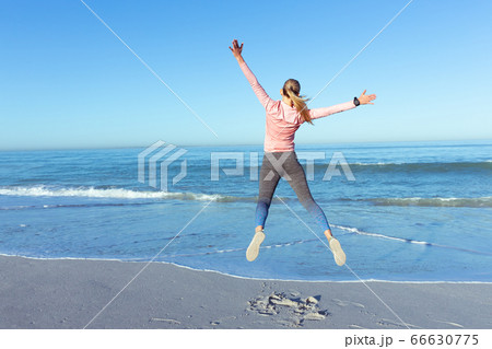 Caucasian woman spending time seaside wearing sportswear 66630775