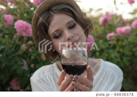 Beautiful young woman with curly hair posing near 66636378