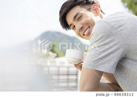屋外でマグカップを持つ若い男性 66638313
